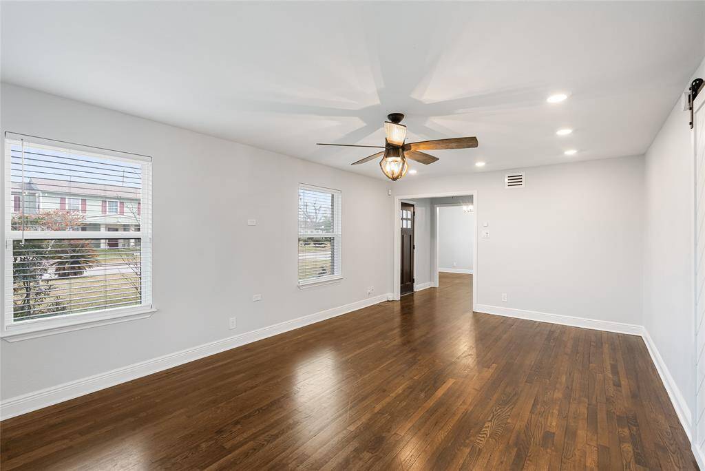 The living room offers picturesque views of the calm street outside! Modern updates include ceiling fan, LED lights and double paned windows.