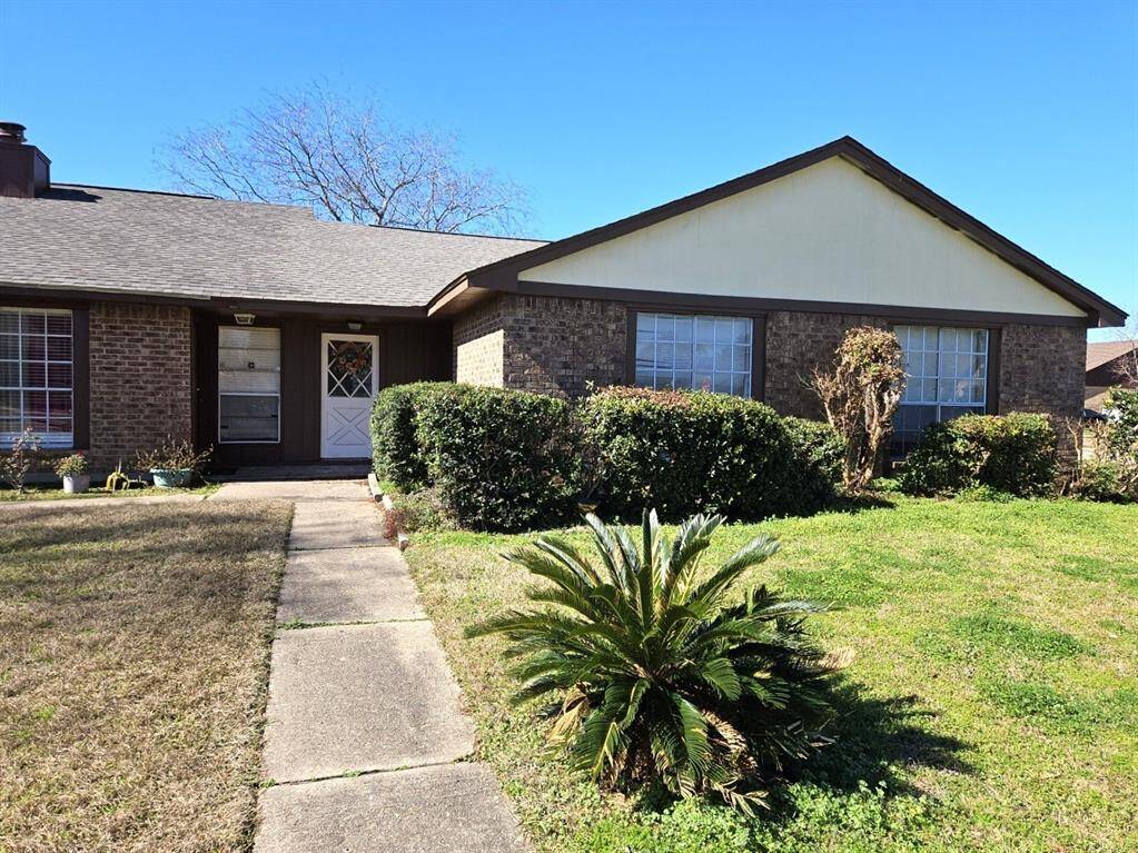 Charming single-story townhome with 2 bedrooms and 2 baths, featuring brick and wood accents, a welcoming walkway, mature landscaping, and large windows. Ideal for those seeking a cozy, well-maintained home.