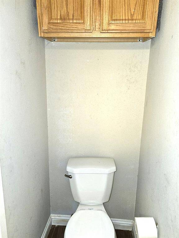 Compact bathroom with convenient overhead storage cabinet.