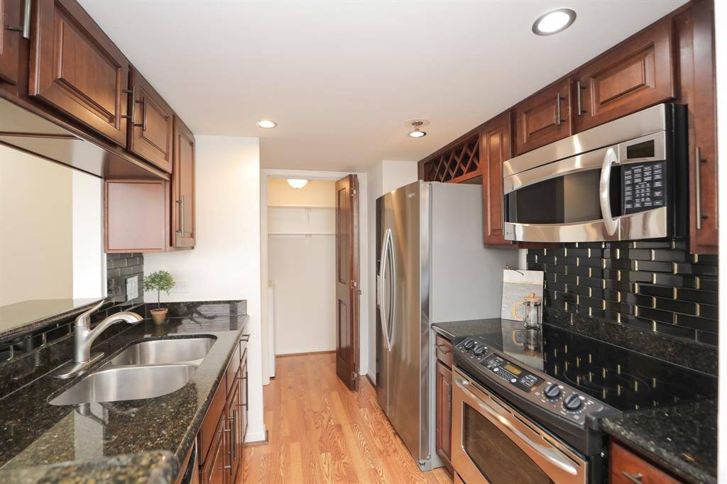Kitchen has ample counter space, cabinet space and wine rack over the included refrigerator. Utility room at end of kitchen with storage.  Washer and dryer included.