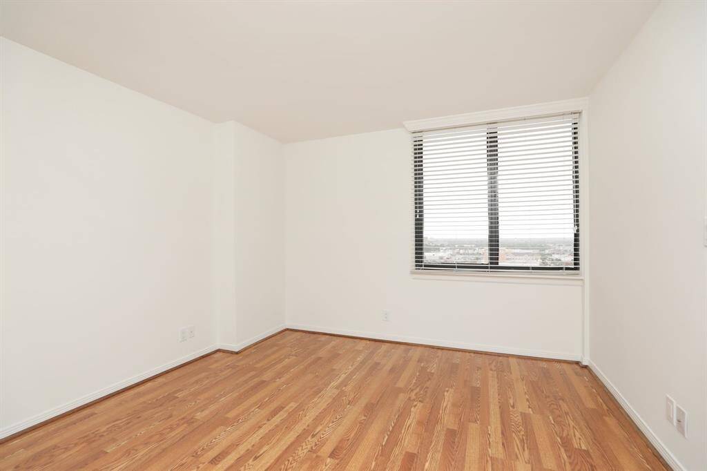 Another view of spacious primary bedroom and crisply painted walls with new flooring.