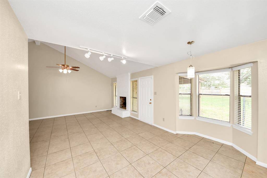 The dining area has bay windows with a view of the backyard.