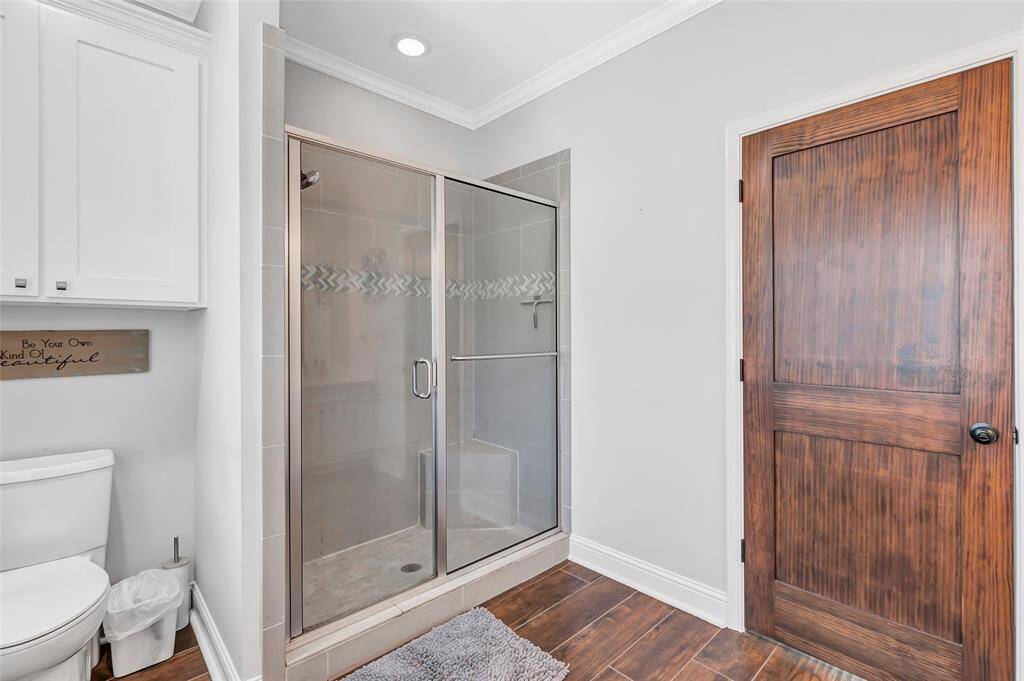 Elegant en-suite bathroom with modern finishes, featuring a sleek glass shower and stylish cabinetry.