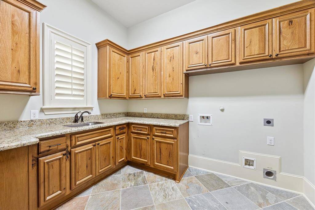 The laundry room offers Hickory wood cabinets, granite counter tops, slate flooring, widow with platation shutter, and a soaking sink. This home includes a CENTRAL VACUUM system!  That’s a total luxury—makes cleaning way easier and keeps the house quieter.