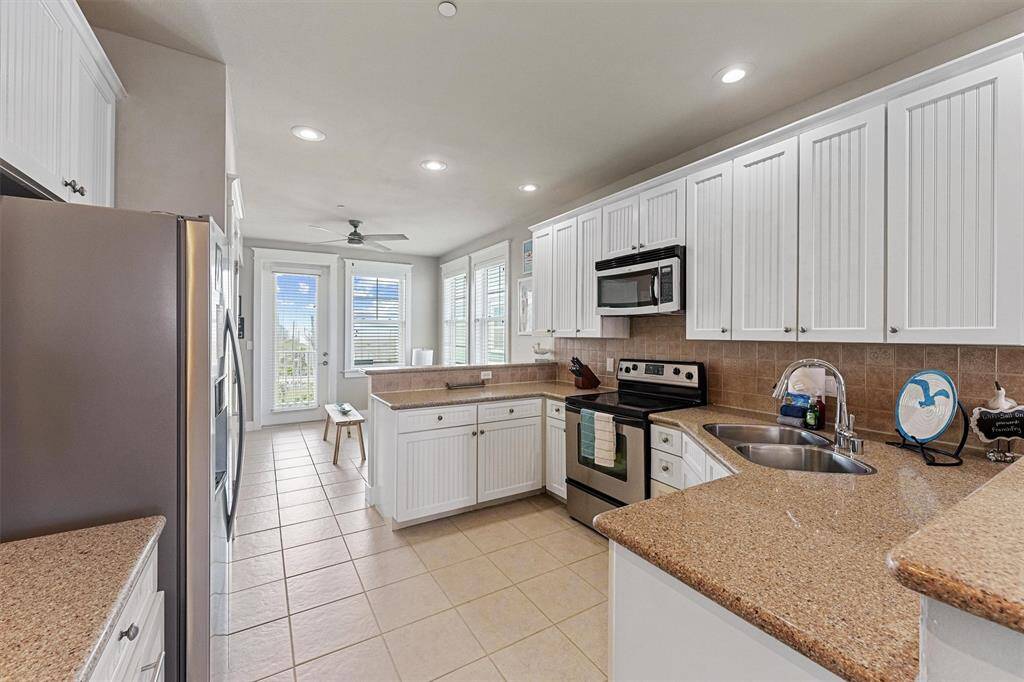 This kitchen features classic white cabinetry, stainless steel appliances, and ample counter space to inspire your inner chef.
