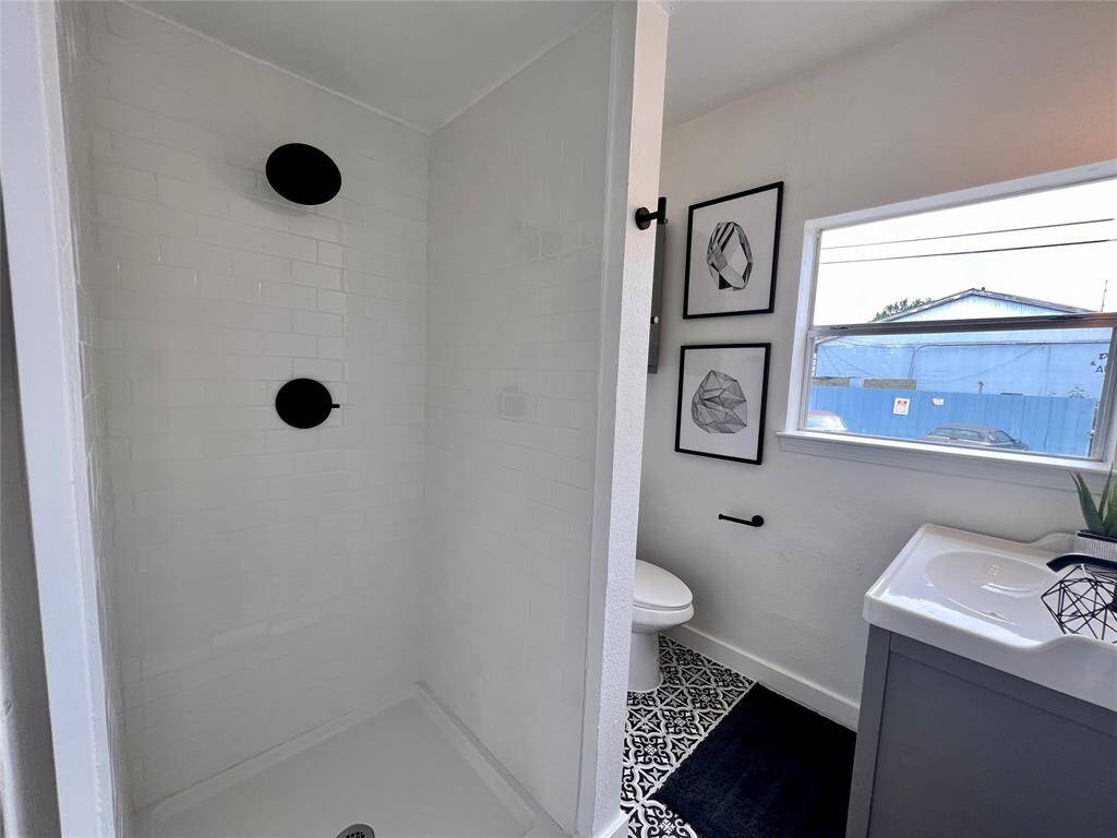 Full walk-in shower with updated flooring and sink.