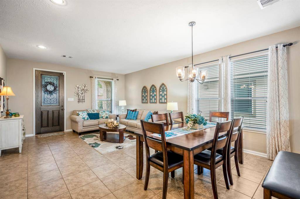 This inviting living-dining area features a warm, neutral color palette with tile flooring.