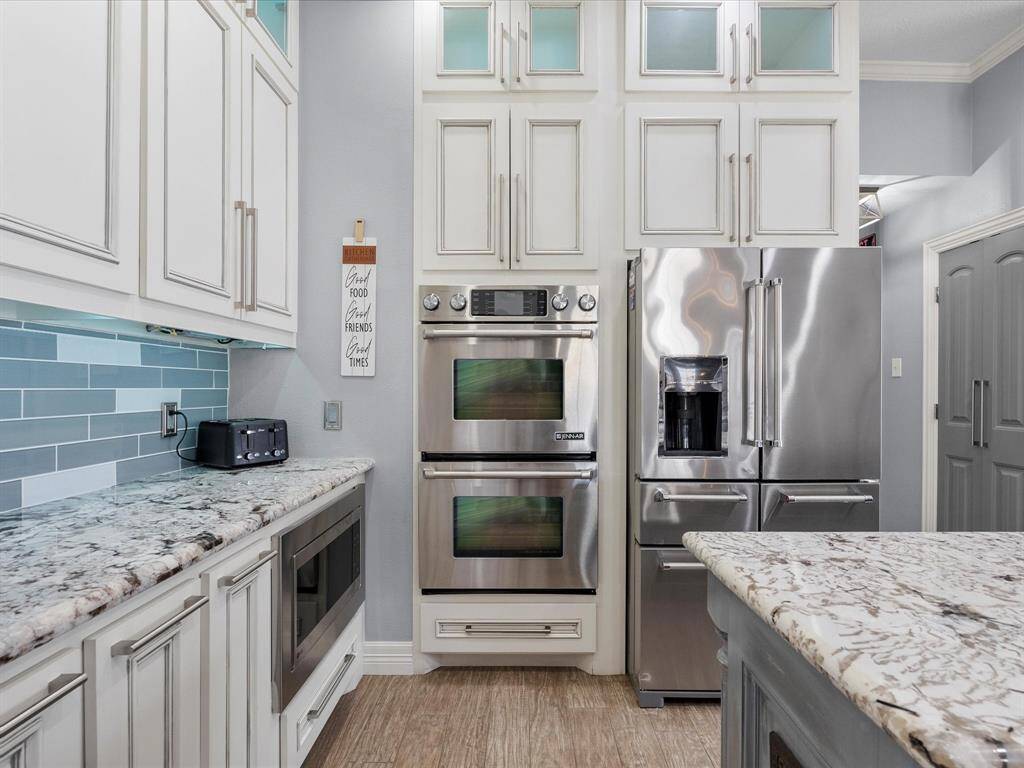 Custom kitchen has upgraded stainless appliances and cabinets from floor to ceiling.