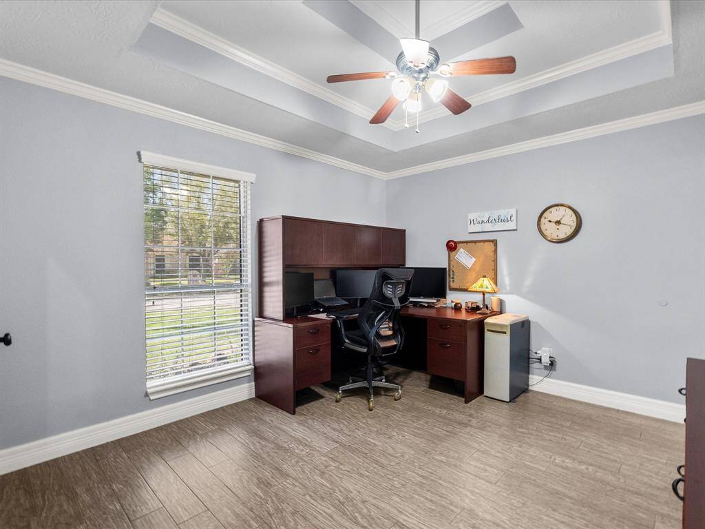 Large space with crown molding and view of the front yard space,
