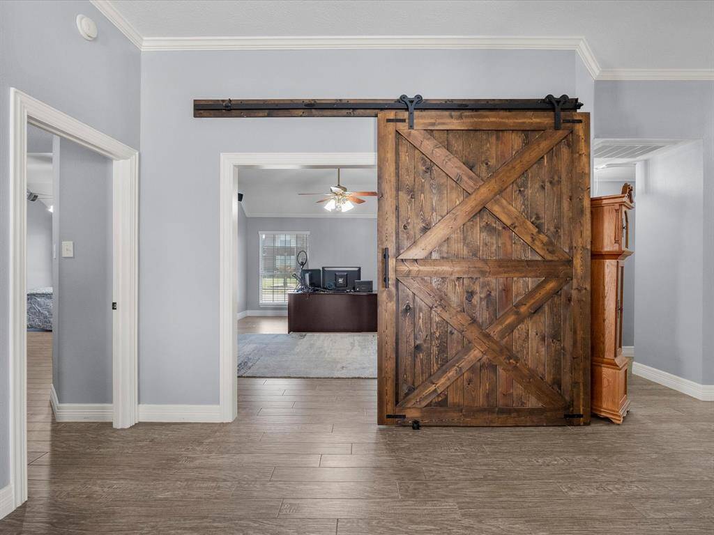 The entry to the. family/game room is framed by a hand-built barn door