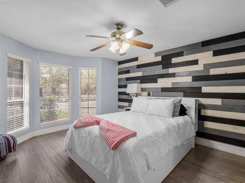 This bedroom has an accent wall and bay window to allow for natural light.