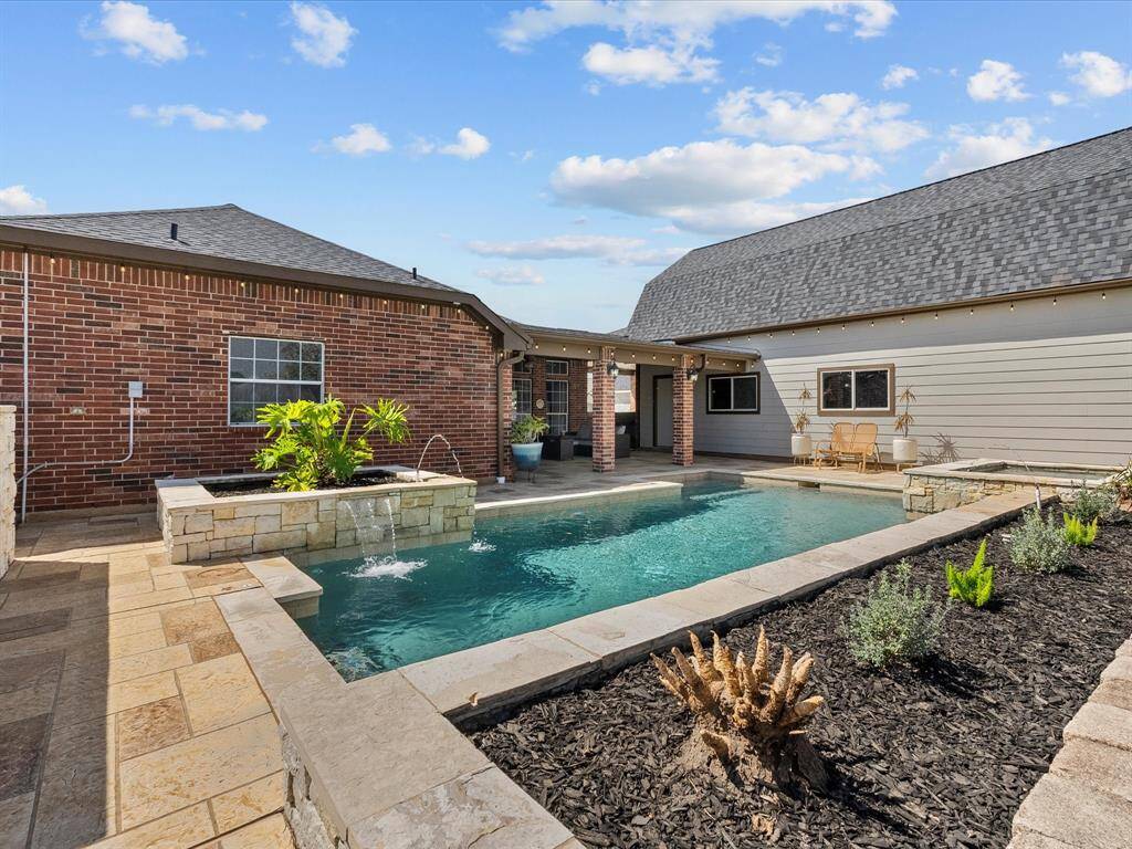 The private backyard features a chlorine swimming pool. Its framed by low maintenance raised beds.