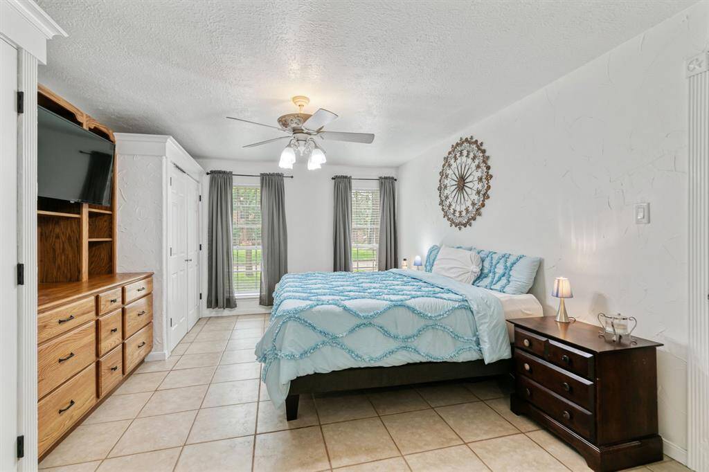 The master bedroom, located on the bottom floor, features built-in closets and cabinetry. The windows offer a view of the front yard