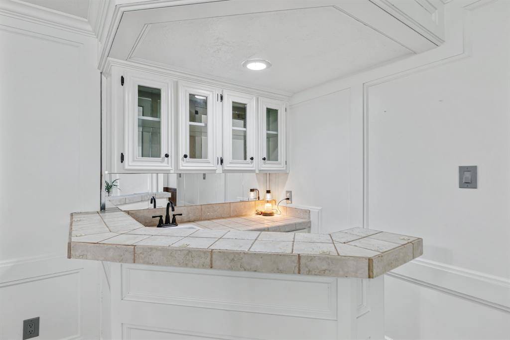 The wet bar is positioned at the back left of the family room, featuring a sink and storage space for entertaining.