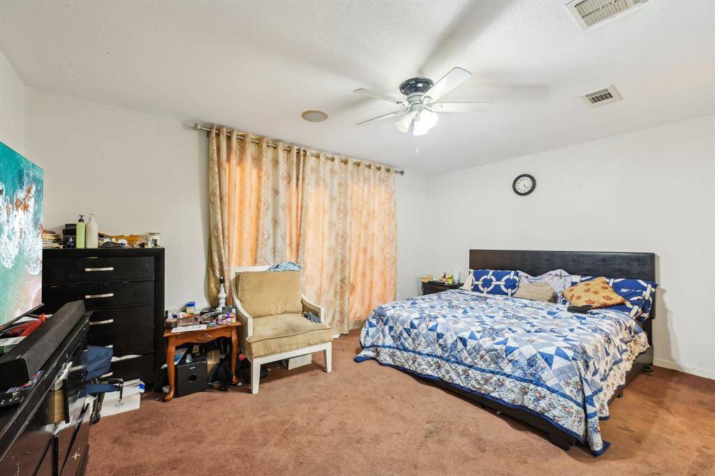 Primary bedroom with door access to open space/pool area