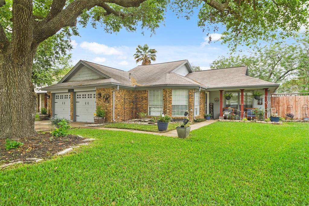 Beautiful ranch-style house with a luscious yard and landscaping.
