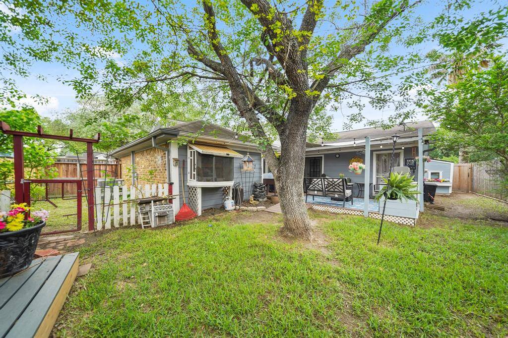 Another view of the backyard with a mature shady tree and a second storage shed at back of property