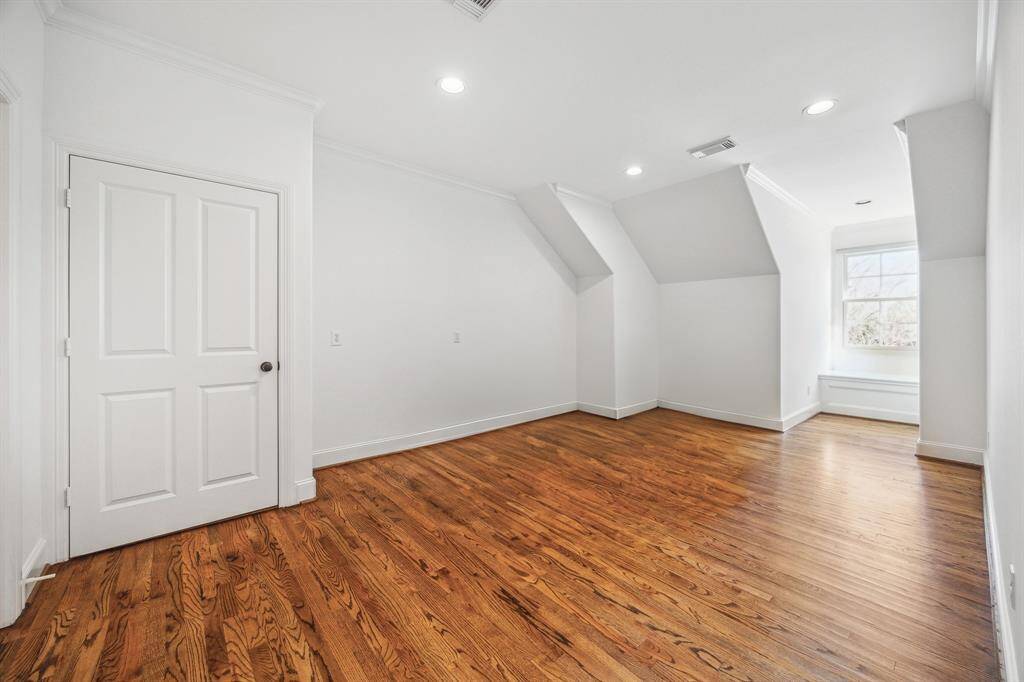 Upstairs game room with hardwoods.  This door leads to 432 SF of unfinished/plumbed attic space.