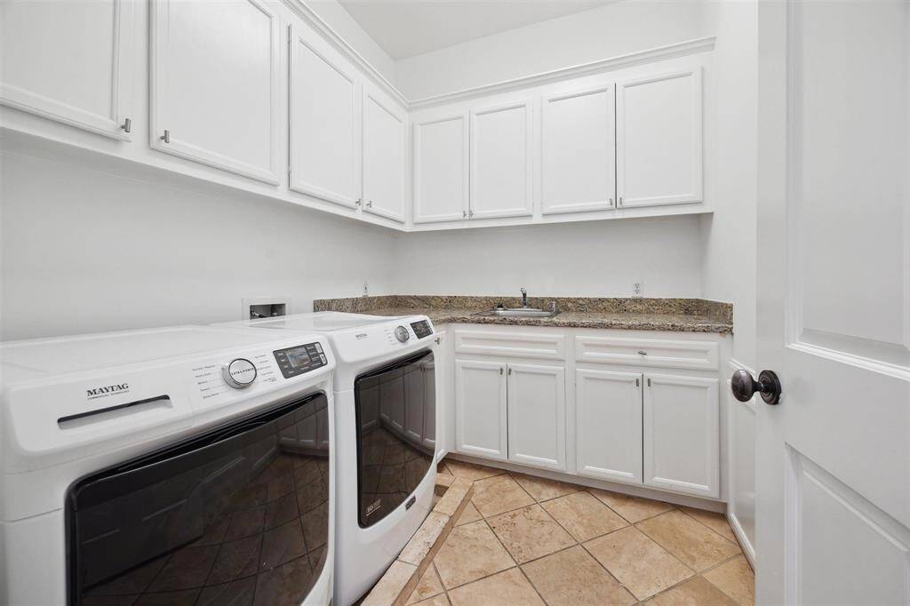 Large downstairs utility room with sink.  Off of the utility is a mud/area which leads to the attached two car garage