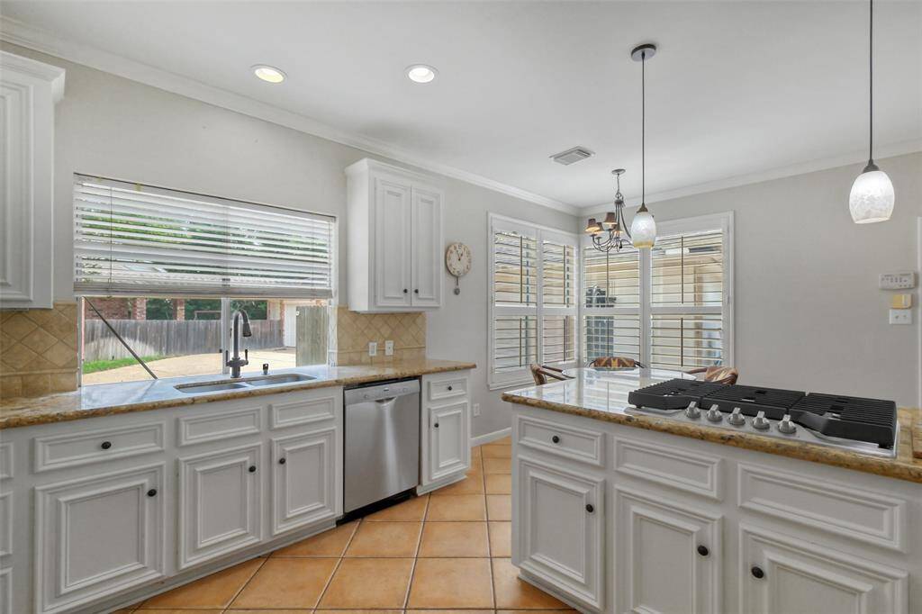 THE CHEF’S KITCHEN FEATURES EYE-CATCHING GRANITE COUNTERS, ABUNDANT CABINETRY, AND A BUILT-IN 5-BURNER GAS COOKTOP—PERFECT FOR MEAL PREP AND ENTERTAINING.