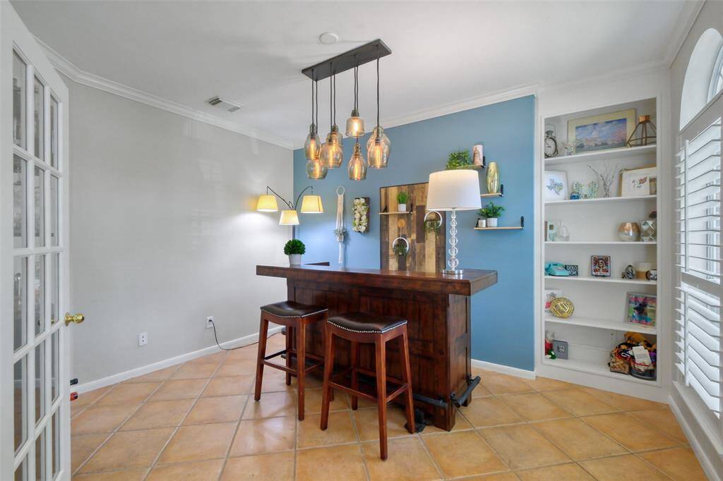 THIS VERSATILE ROOM CAN ALSO BE USED AS A PRIVATE STUDY OR A COZY LIVING ROOM, COMPLETE WITH BUILT-IN SHELVING AND TONS OF NATURAL LIGHT.