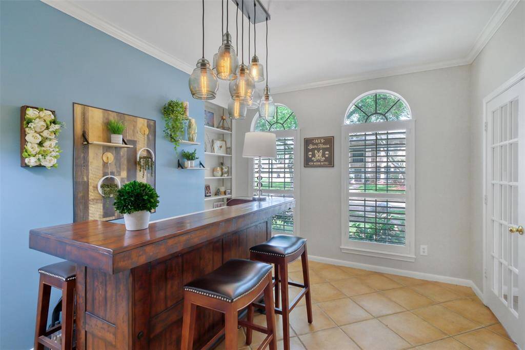 TWO LARGE ARCH-TOP WINDOWS AND GLASS FRENCH DOORS FLOOD THE ROOM WITH NATURAL LIGHT.