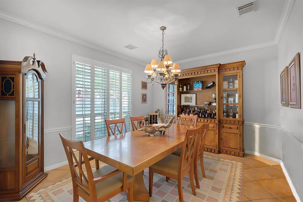 THE FORMAL DINING ROOM FEATURES CLASSIC CROWN MOLDING, AND LARGE PLANTATION SHUTTERS.