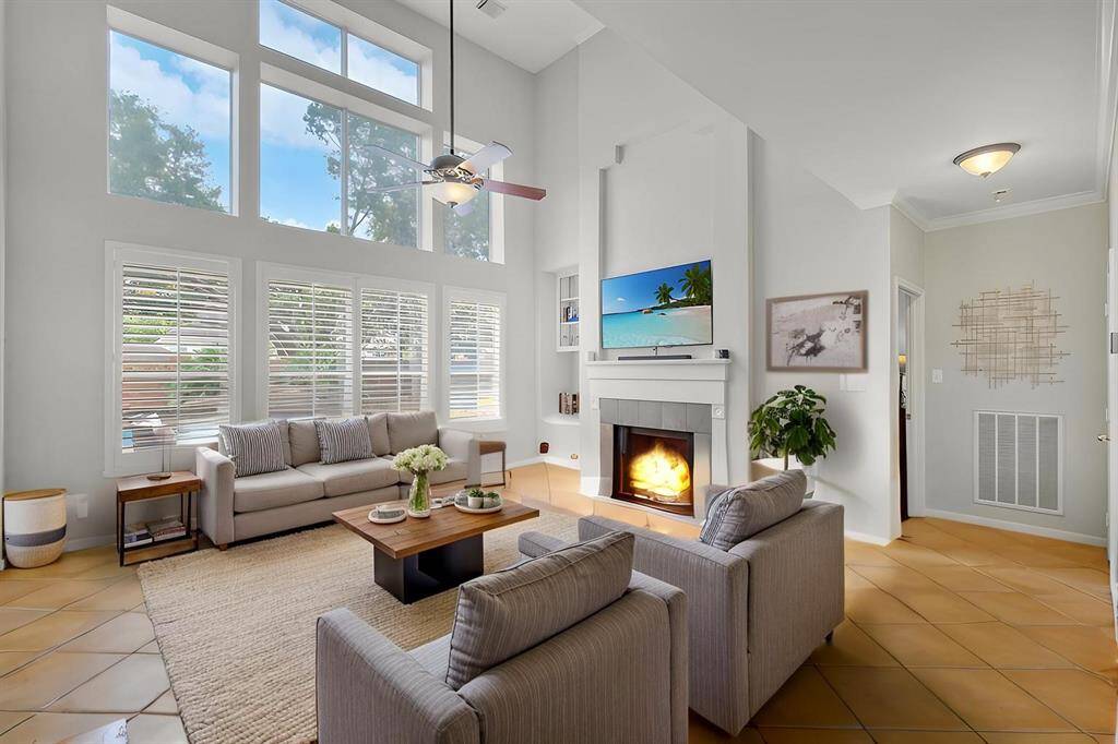 THE SOARING TWO-STORY CEILING CREATES AN OPEN FEEL WHILE A WALL OF WINDOWS PROVIDES STUNNING VIEWS OF THE POOL AND BACKYARD OASIS. **This room has been virtually staged.