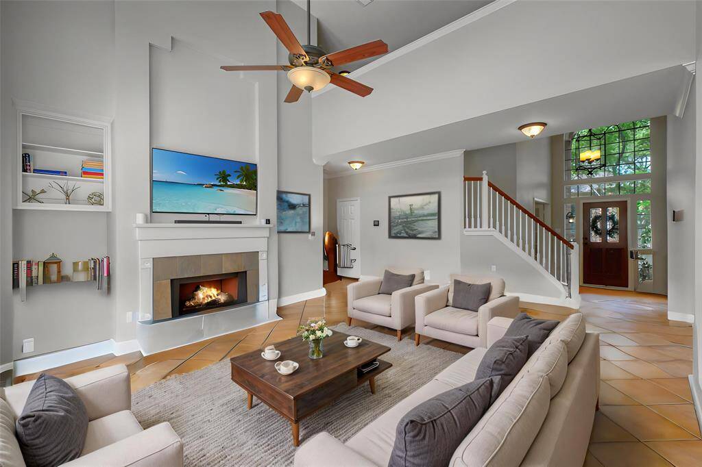THE COZY FIREPLACE SERVES AS A STUNNING FOCAL POINT, FRAMED BY CUSTOM BUILT-INS AND ELEVATED BY A MODERN MANTEL THAT REACHES TOWARD THE SOARING CEILINGS. **This room has been virtually staged.