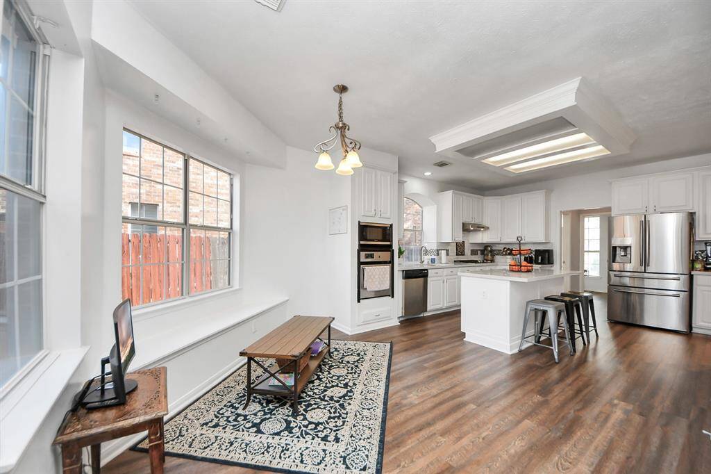 This cheerful breakfast room includes excellent lighting and a charming window seat. Nearby glass door leads to the covered patio.