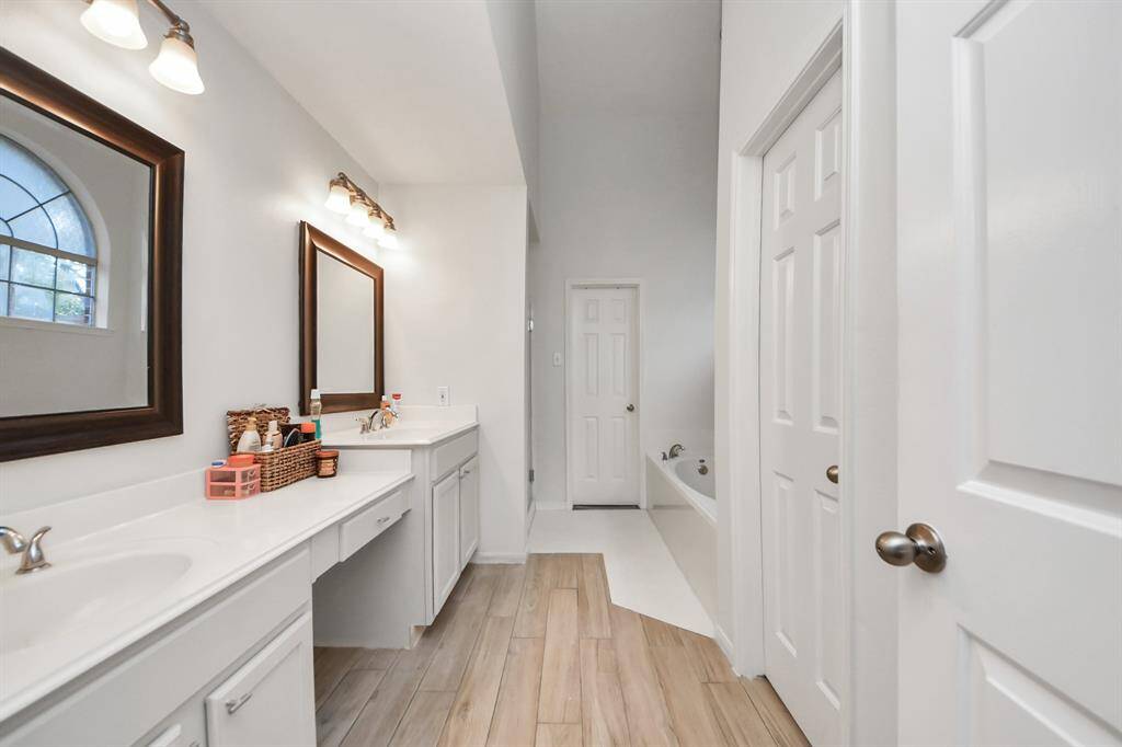Primary bath features double sinks, dual level vanity space, tons of built in cabinets and separate tub and walk in shower.
