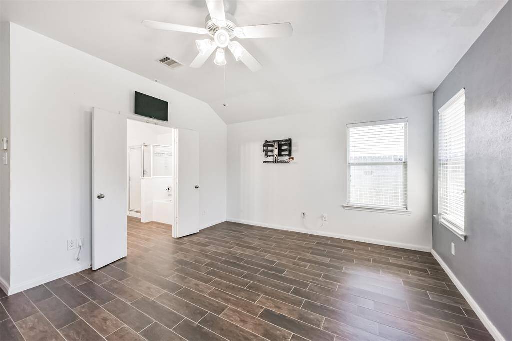 Another perspective of the primary bedroom highlights its fresh coat of paint and the soft glow of natural light streaming through the windows.