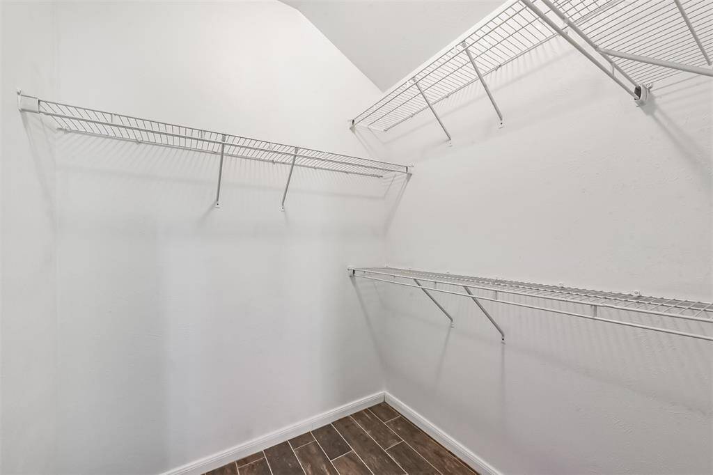 A large walk-in closet in the primary bedroom, thoughtfully designed with shelves to provide ample storage and organization options.
