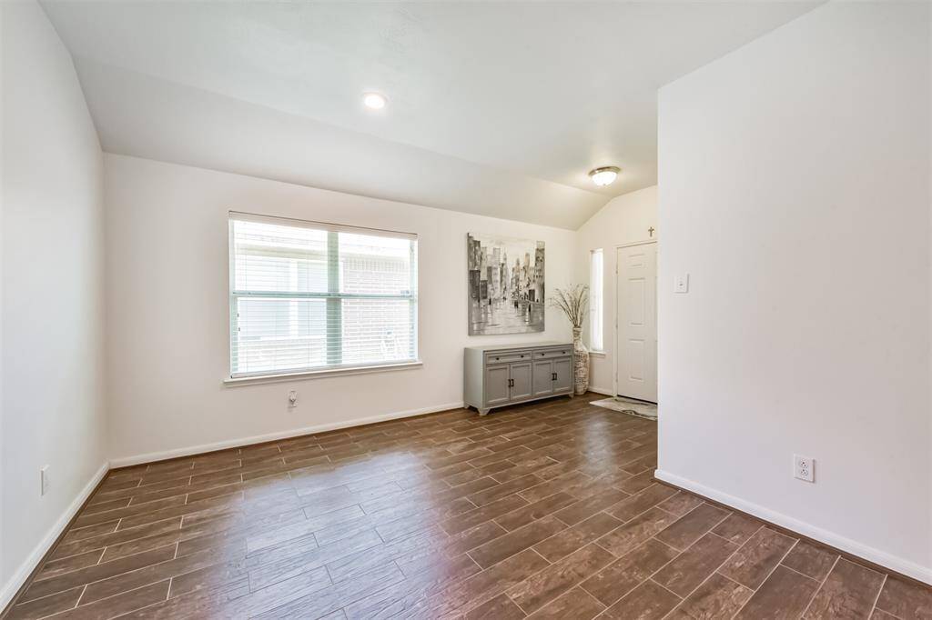 Expansive den with recessed lighting, versatile enough to serve as a formal dining area or elegant living space with lots of natural light.