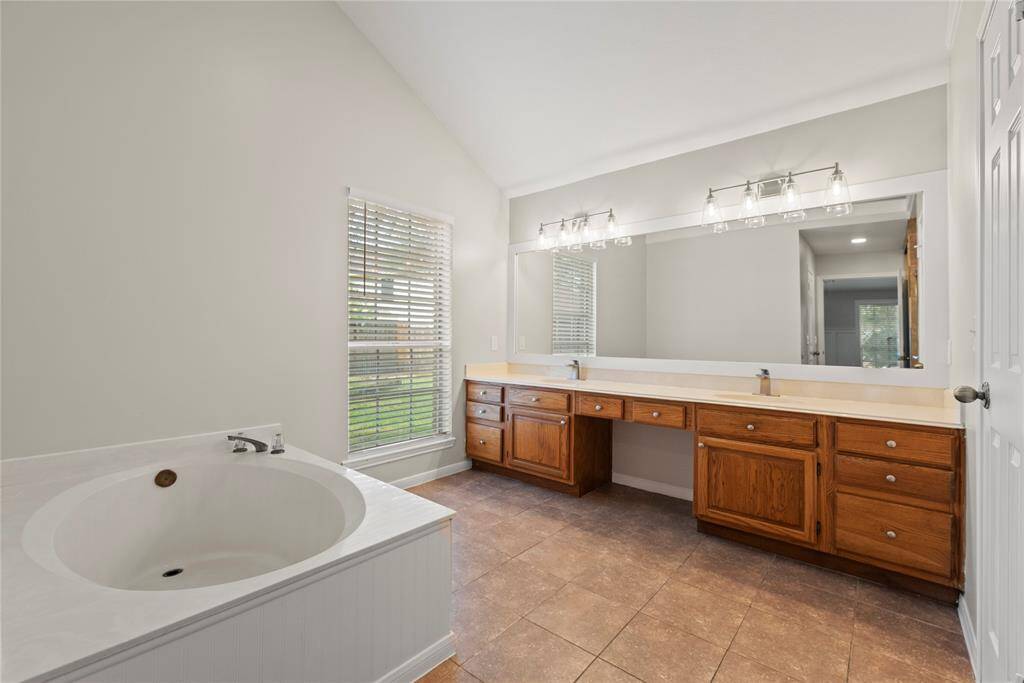 Primary bathroom has a dual sink vanity and garden shower.