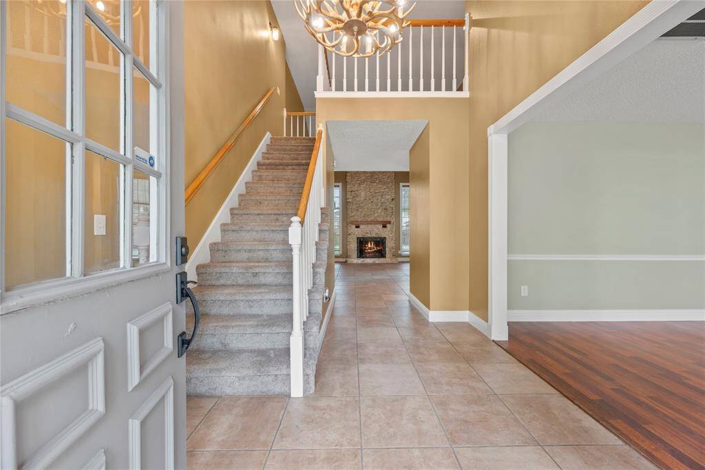 Inviting front entry with tile flooring and a high ceiling.