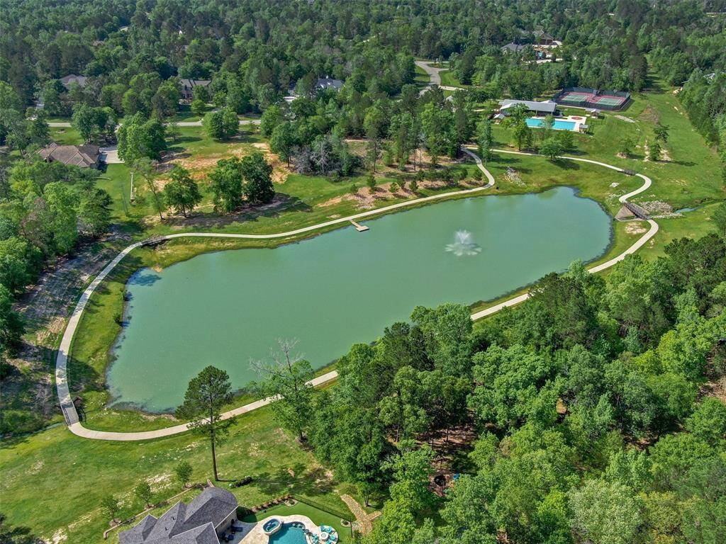 Lush greenery, featuring a picturesque pond with a central fountain, walking paths, and nearby amenities including a swimming pool and tennis courts. Ideal for those seeking a tranquil, nature-rich environment.