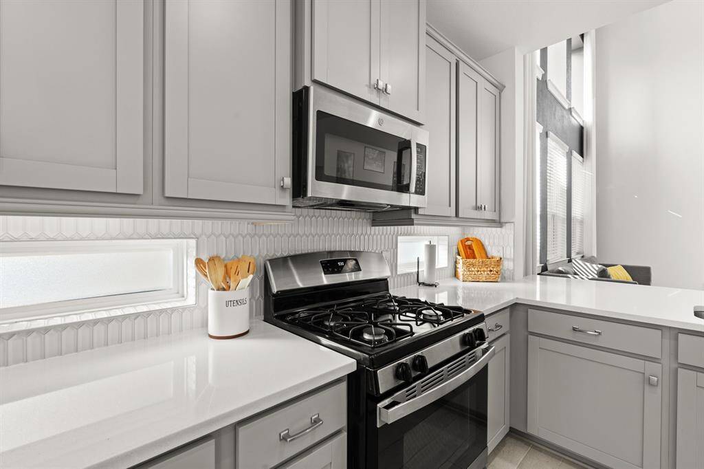 Pocket windows & white counters with white backsplash, creating a clean & timeless aesthetic.