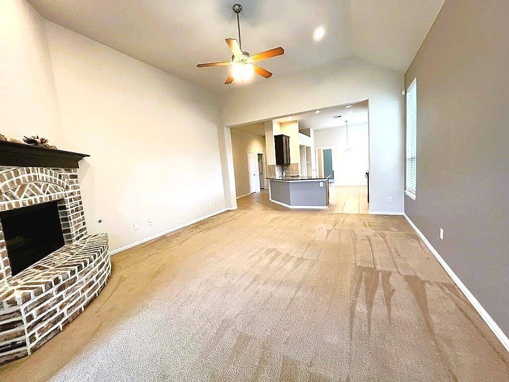 Bright and airy living room with vaulted ceilings and a cozy & stunning stone surround fireplace.