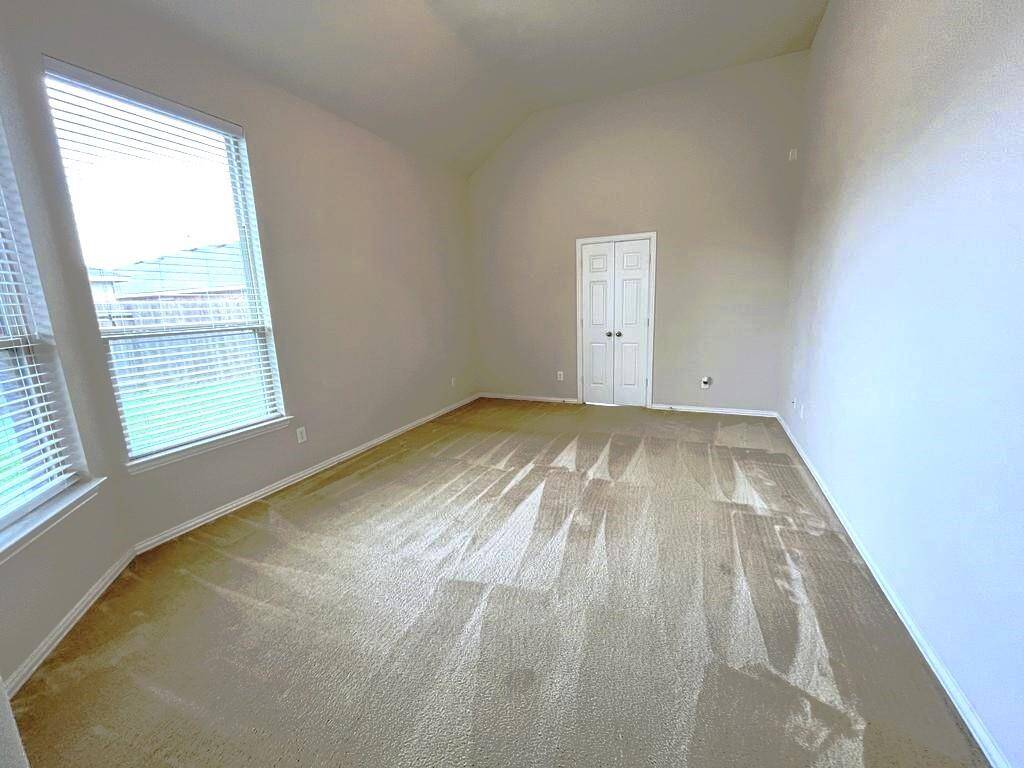 Generously sized primary bedroom featuring a charming bay window and picturesque views of the backyard.