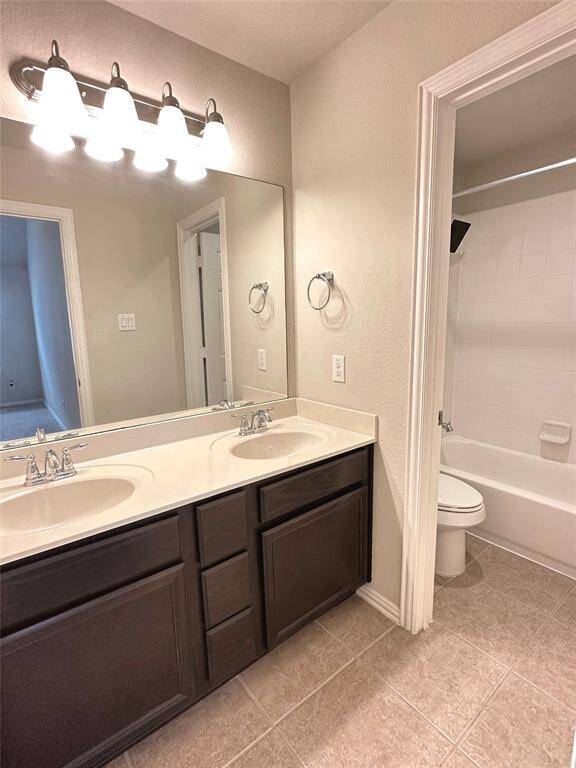 Hallway bathroom with double vanity and a separate shower and toilet area for added privacy.