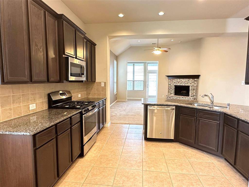 Spacious kitchen with rich wood cabinetry, stainless steel appliances, and an open-concept layout