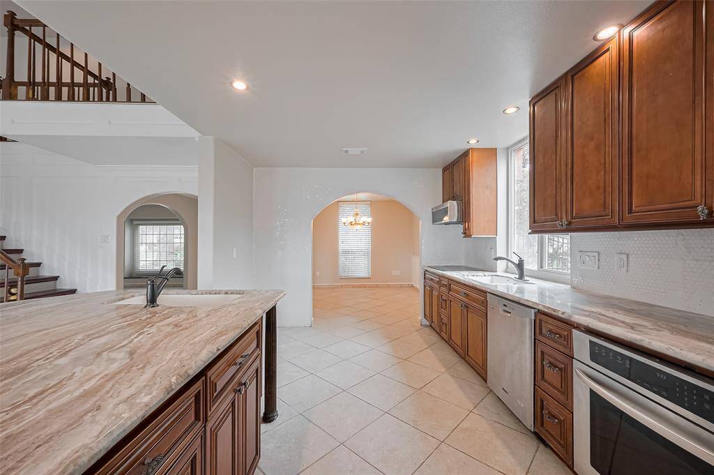 Enjoy plenty of counter space and a deep sink overlooking the backyard. The kitchen opens into the dining area through a beautiful arched entryway, making meal service and flow effortless.