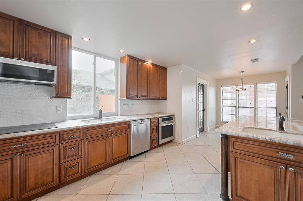 Stainless steel appliances, extensive cabinetry, and an abundance of natural light make this kitchen a standout. The blend of wood tones and sleek finishes creates a warm and modern culinary space.