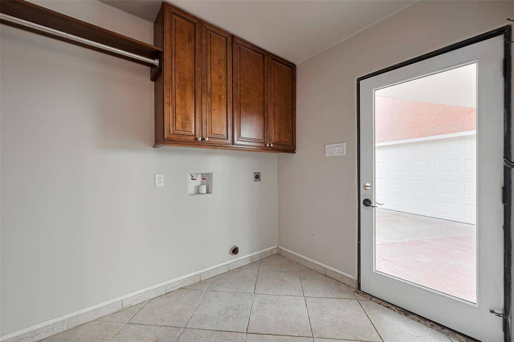Laudry room space, with half bath also located here. Real, wood cabinets for extra storage. Door takes you to the breezeway and the detached garage.