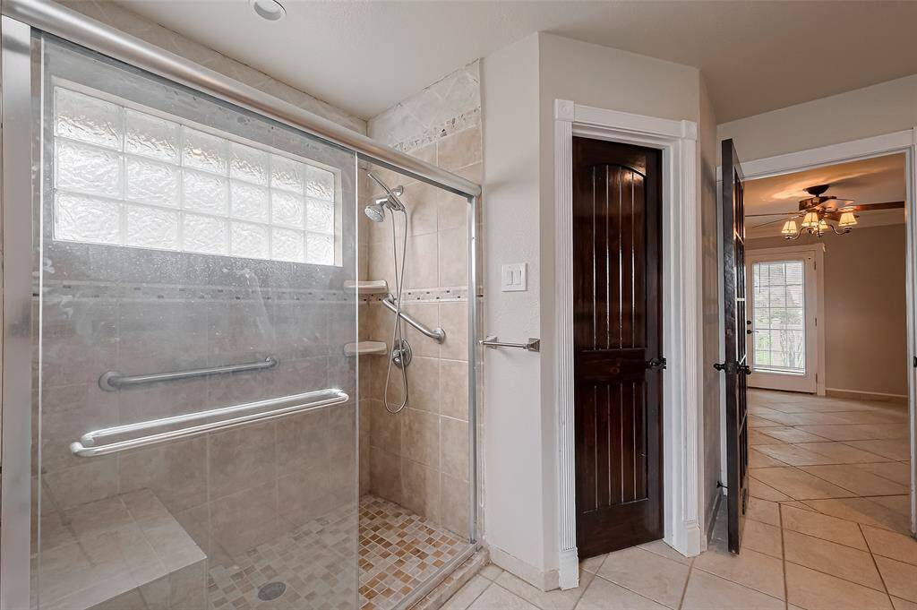 This primary bath is both elegant and functional, featuring a large walk-in shower, double sinks, and rich finishes that blend comfort with timeless design.