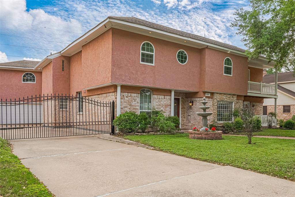 A private gated driveway leads to the spacious garage, adding both security and elegance. The manicured front yard is anchored by a tiered fountain surrounded by vibrant flowers, offering a peaceful and polished entrance to your new home.