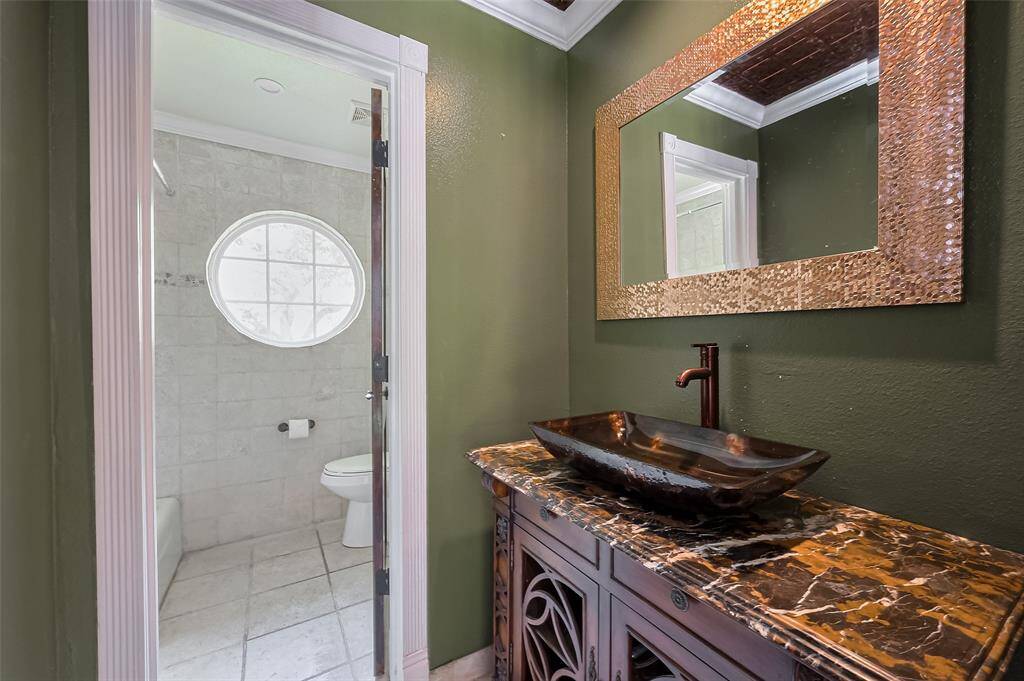 Upstairs Bathroom #3- with closed door access to allow for double access. Combo shower and tub in this full bathroom. Designer details including hammered copper vessel sink, dark marble countertop and coordinating framed mirror.