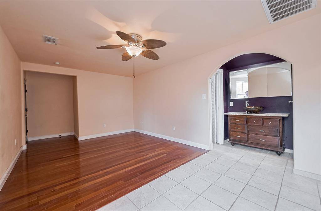 Flexible living space with wood and tile flooring offers an open layout that transitions into a second kitchen—ideal for multi-generational living.