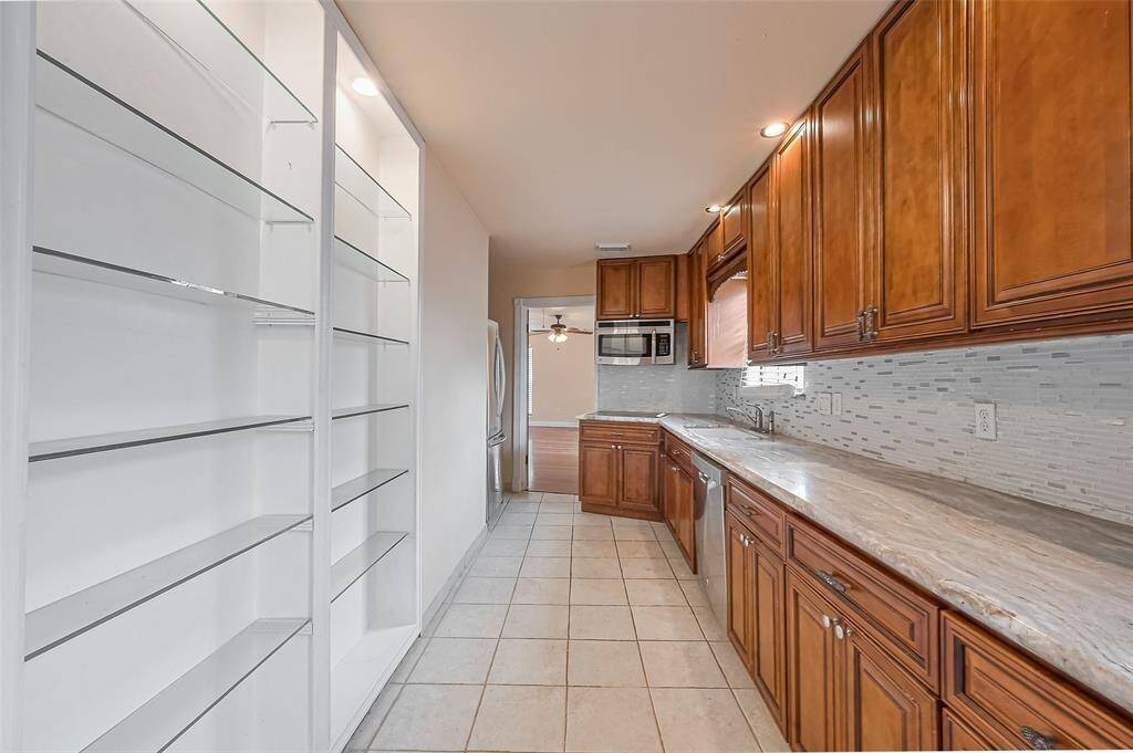 Enjoy added storage and prep space in this extended second kitchen area with a bright window, deep double sink, and upgraded cabinetry.